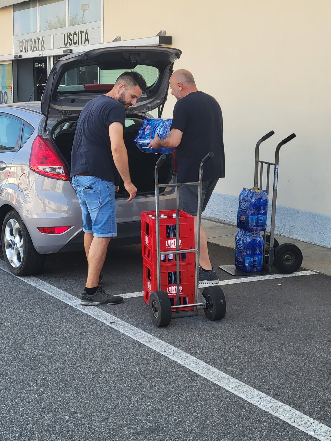 Staff che porta scatole verso un’auto