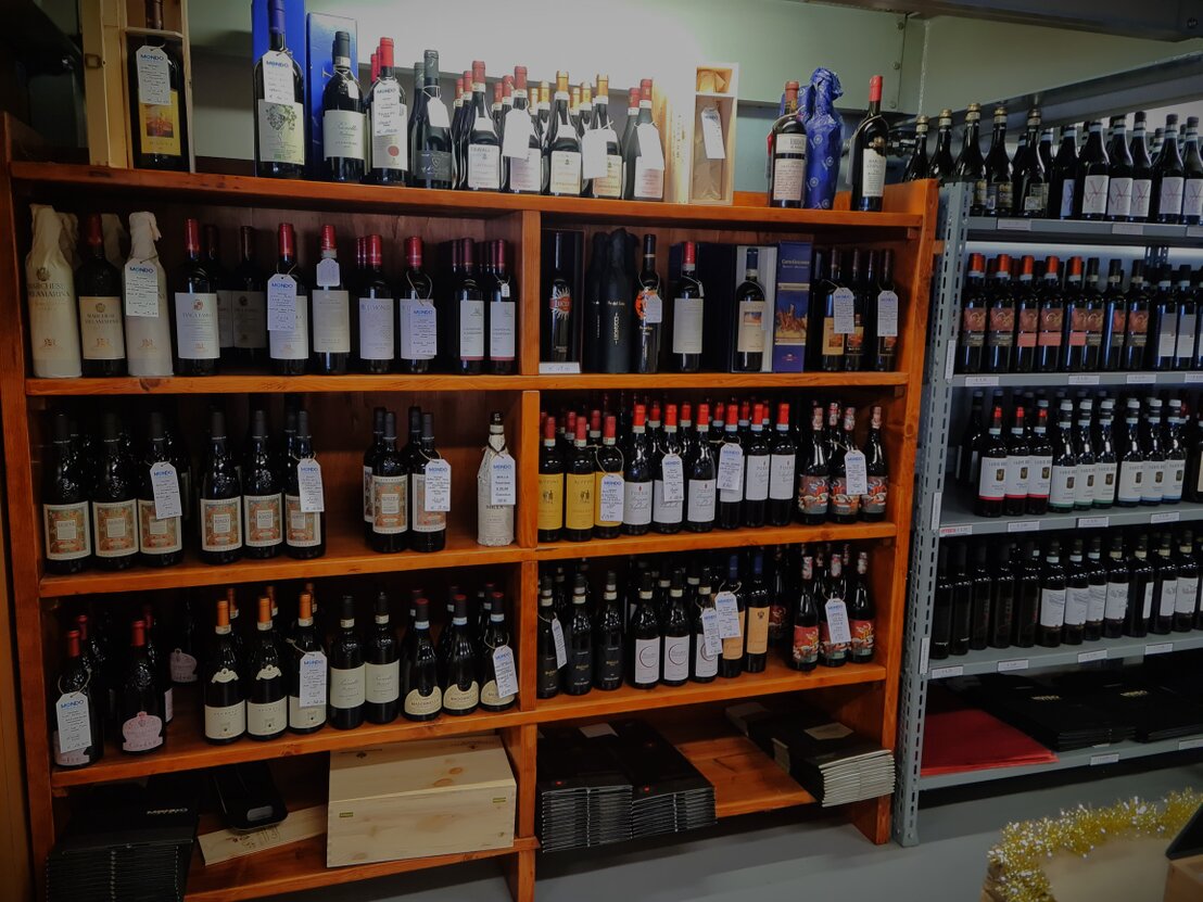 Lunga parete di scaffali con bottiglie di vino